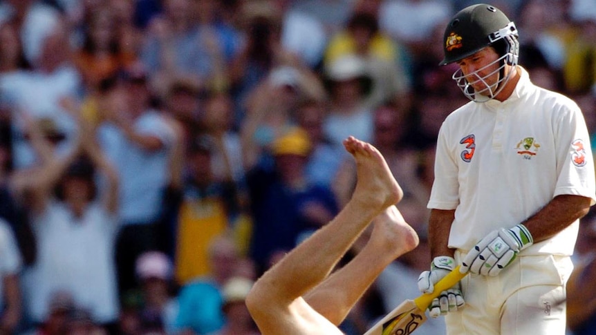 Ricky Ponting looks unamused as a streaker rolls down the pitch.