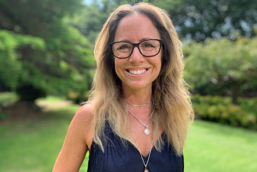 A woman smiles at the camera.