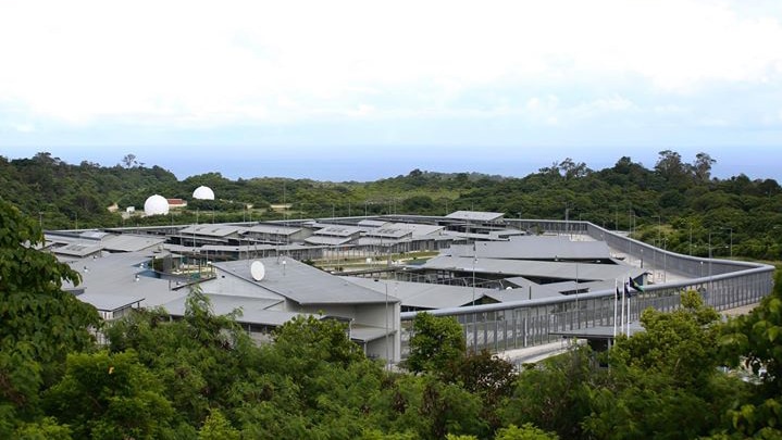 A wide aerial shot of Christmas Island Detention Centre in the daytime surrounded by trees.