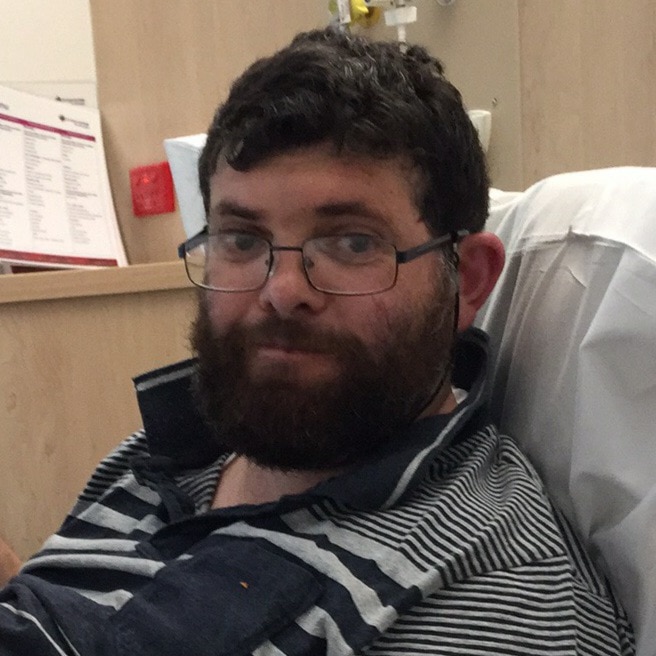 Glen Hardwick sitting in a hospital bed.