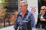 A woman wearing a collared shirt exits the Darwin Local Court.