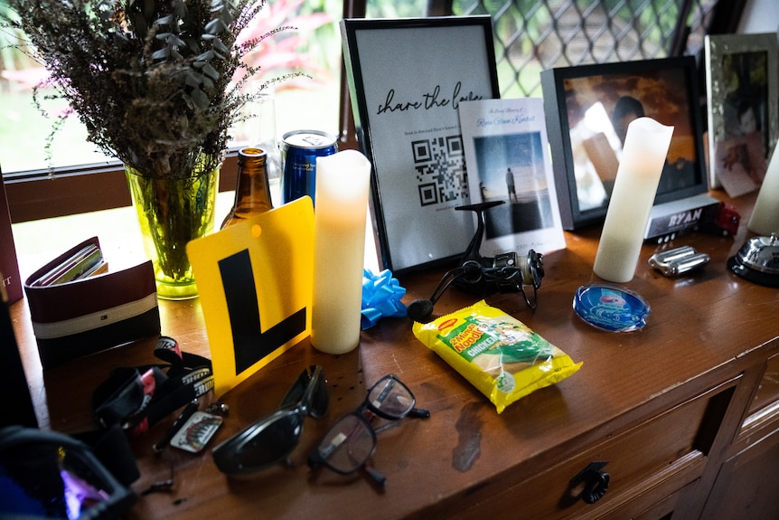 A dressing table with an L-plate, glasses and candles on it.