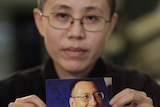 Liu Xia holds a photo of Liu Xiaobo
