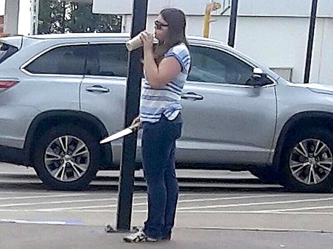 A woman with a knife standing outside Hungry Jack's in West Hoxton