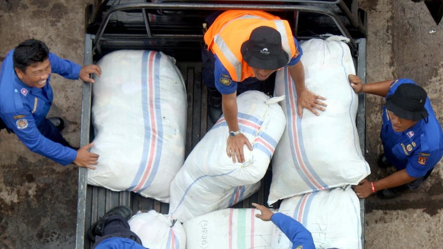 No rot: Workers load aid goods for tsunami victims onto a supply ship at the port of Padang.