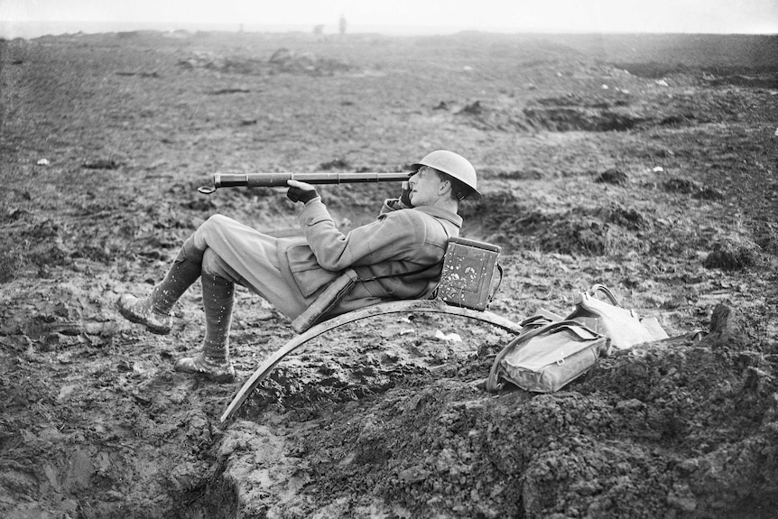 Captain Charles E W Bean watching the Australian advance through a telescope.