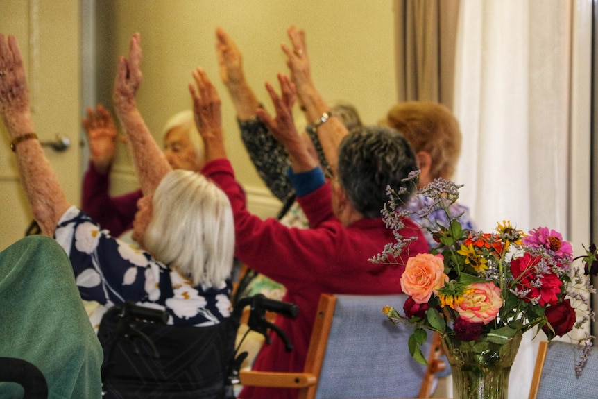 Aged care residents with arms in the air