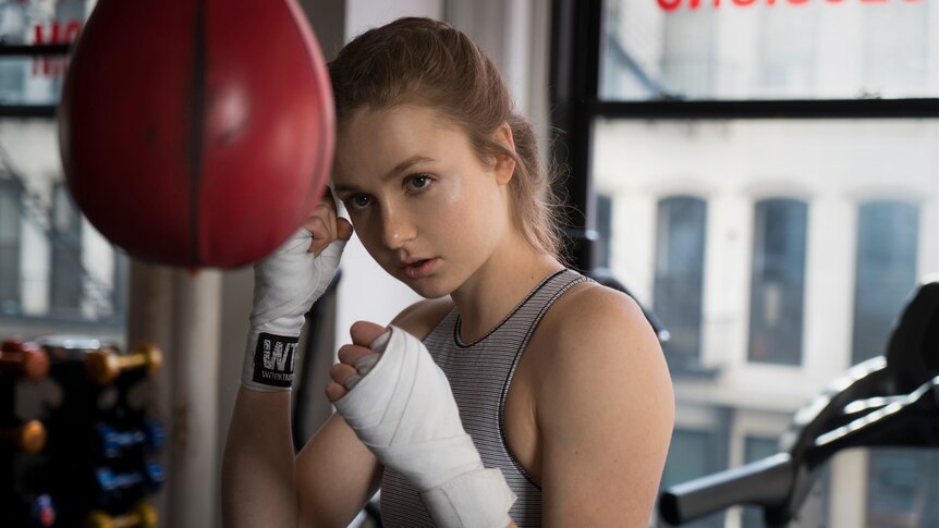 Young woman boxing in gym.