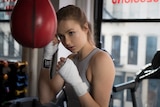 Young woman boxing in gym.