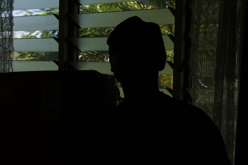 A silhouette of a man against a bright window. 