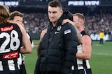 A Collingwood player looks dejected after being injured in the Magpies' preliminary final win.