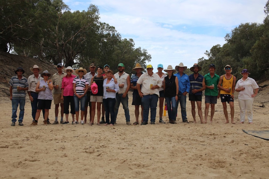 Picture of about 20 people gathered together for the community cricket match