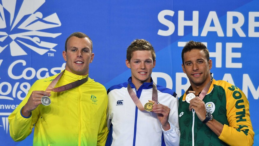 Swimmers Kyle Chalmers, Duncan Scott and Chad le Clos holding their medals on the podium