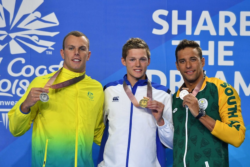 Swimmers Kyle Chalmers, Duncan Scott and Chad le Clos holding their medals on the podium