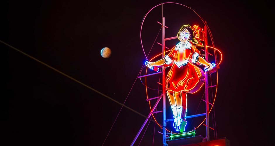 940 pixels The lunar eclipse, or 'blood Moon' rises over a neon sign in Richmond, Victoria on October 8, 2014