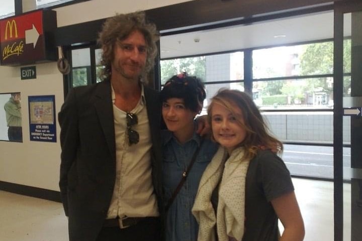 a young girl with a man and a woman in the doorway of the royal childrens hospital.