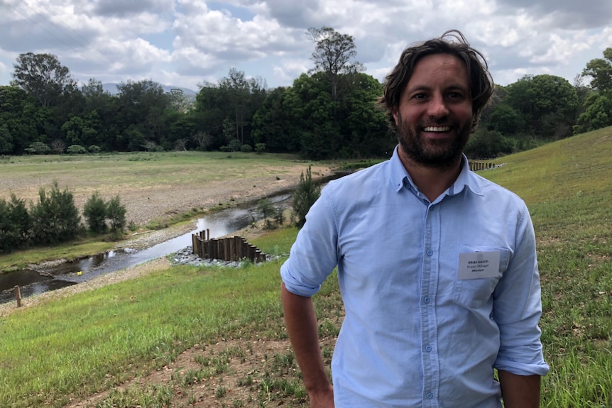 Alluvium Consulting's Misko Ivezich standing in front of the repaired stretch of river.