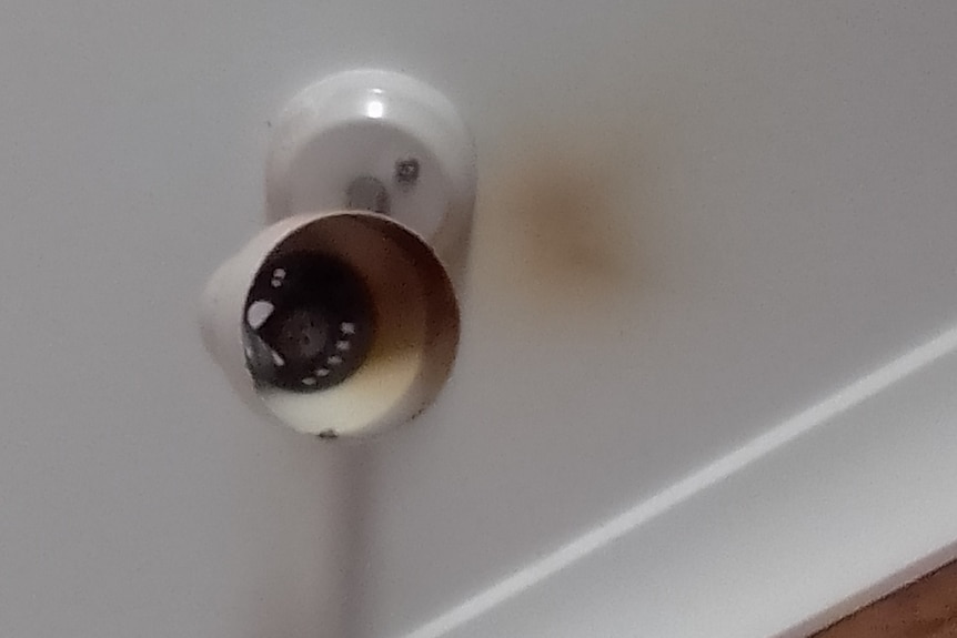 A burnt light with smoke damage on the ceiling.