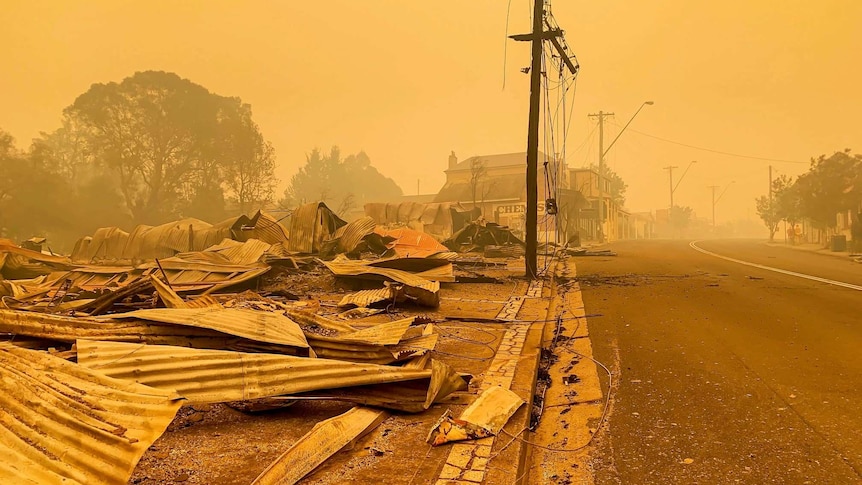 Main street of Cobargo with buildings in ruin and smoky sky.