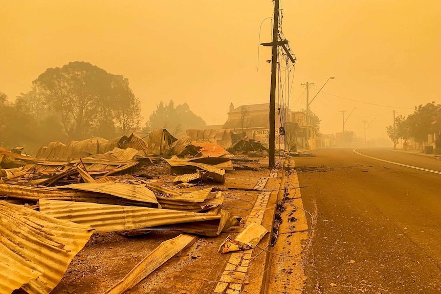 Main street of Cobargo with buildings in ruin and smoky sky.