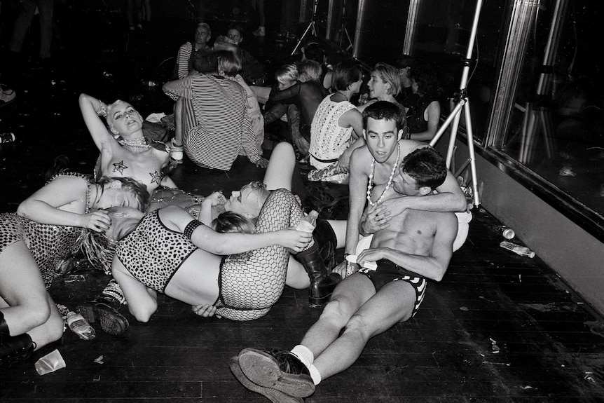 A black and white photo of a bunch of young queer people at a party in the early 90s