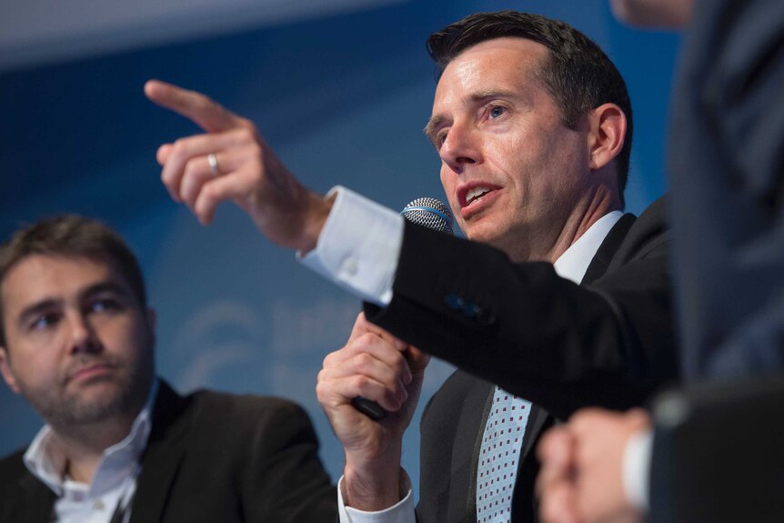 David Plouffe, Uber's senior vice president of policy and strategy, points a finger while speaking on a stage.
