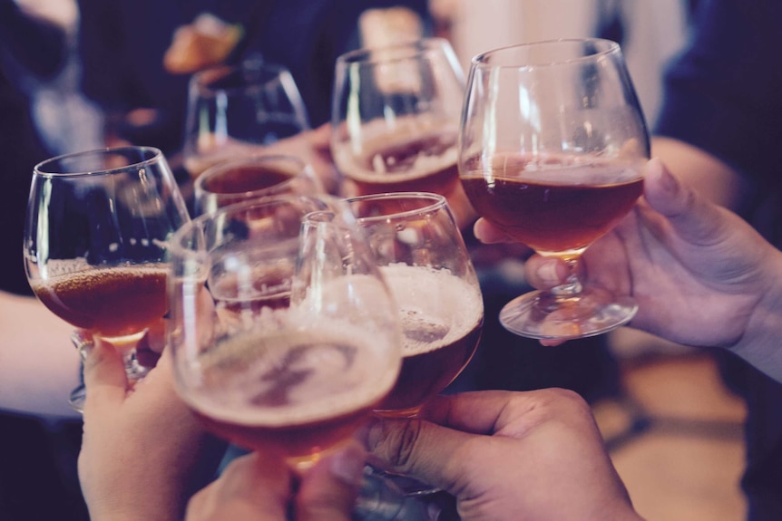 Several glasses of beer being raised