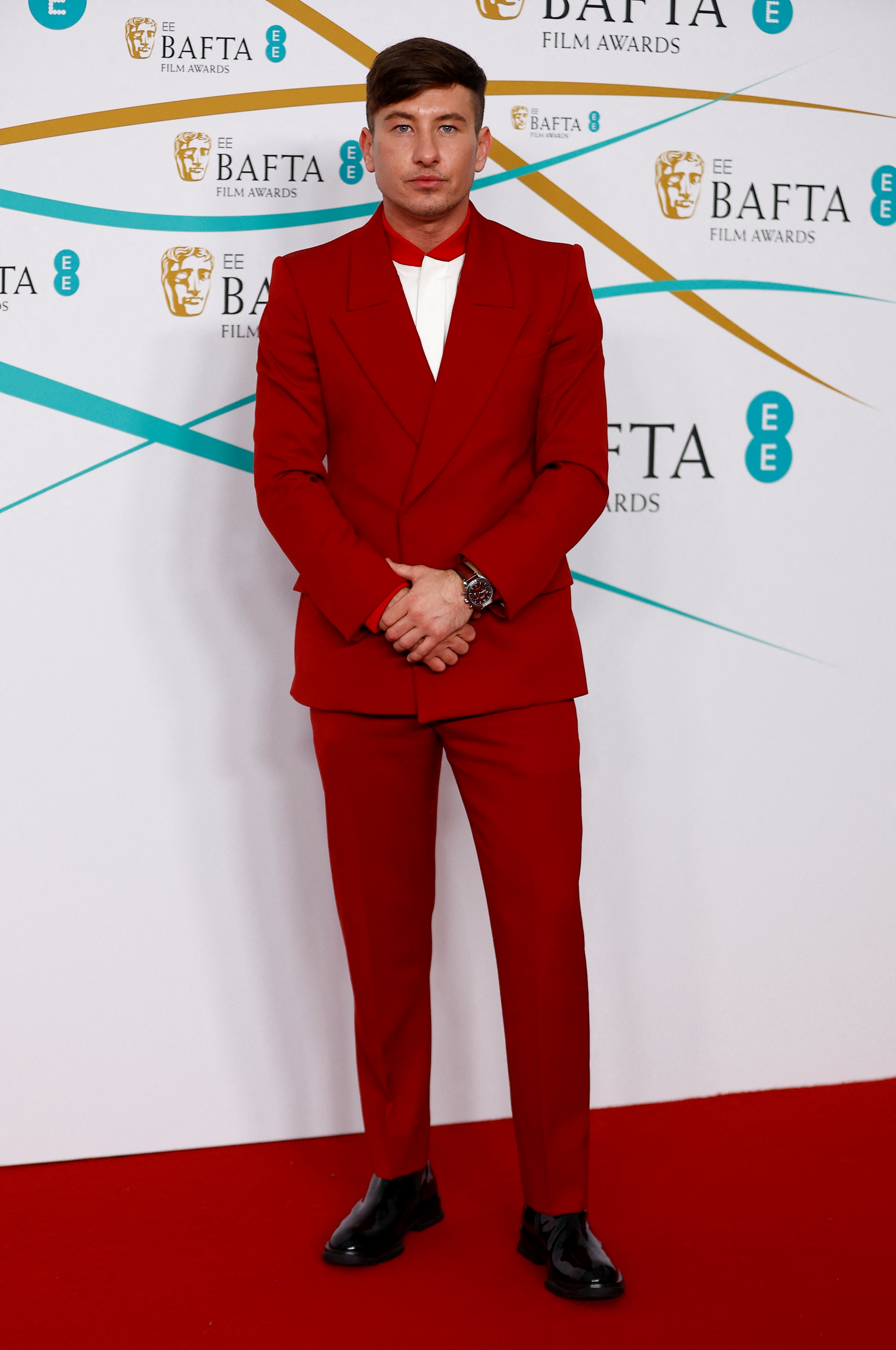Barry Keoghan wearing an all-red slim-fit suit with a white button-up shirt with a red collar underneath.