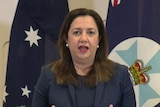 Queensland Premier Annastacia Palaszczuk stands in front of the press.