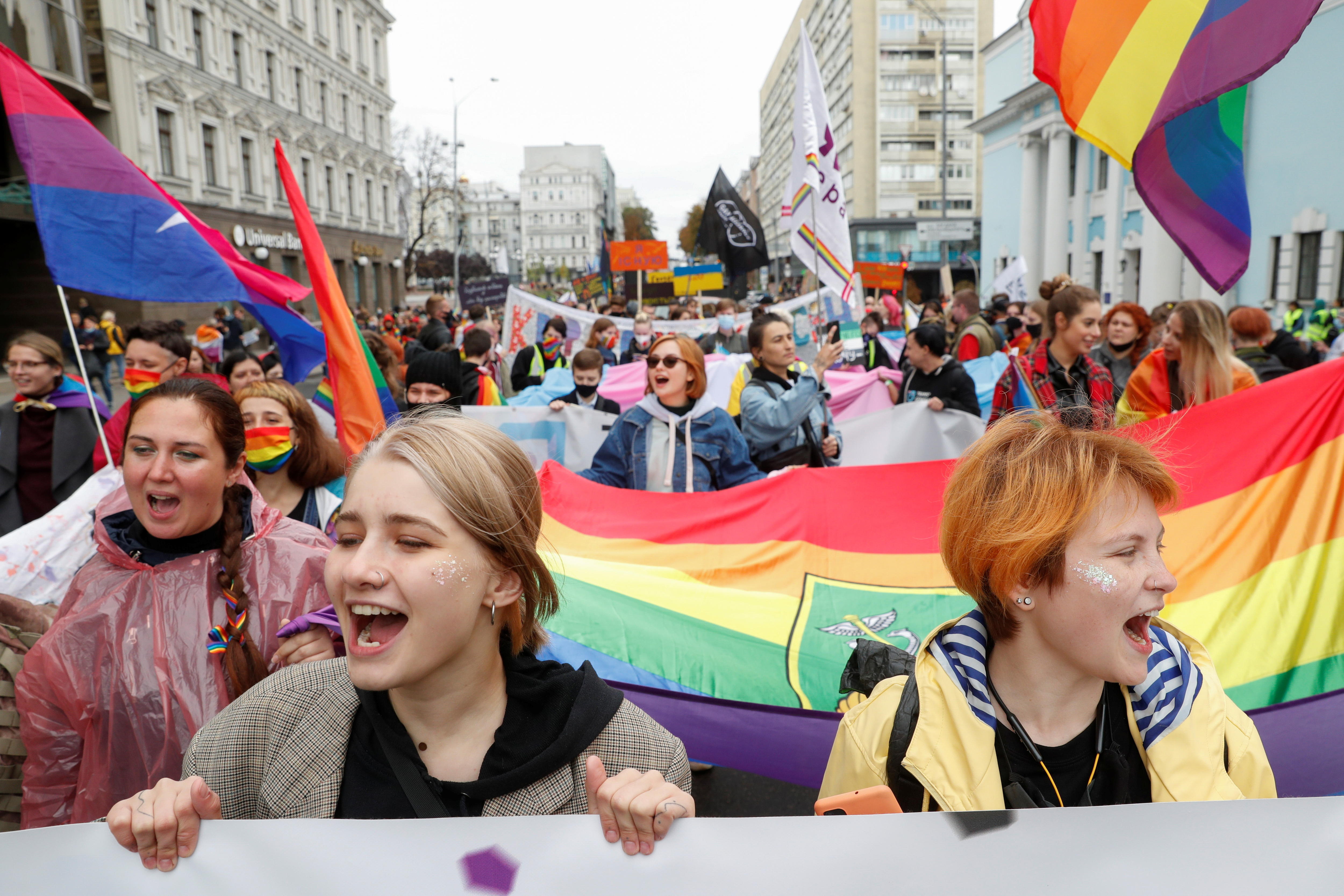 人们在基辅参加骄傲游行，手举彩虹旗并高呼口号。 