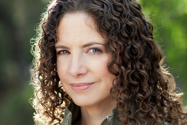 A portrait of smiling woman with curly hair.