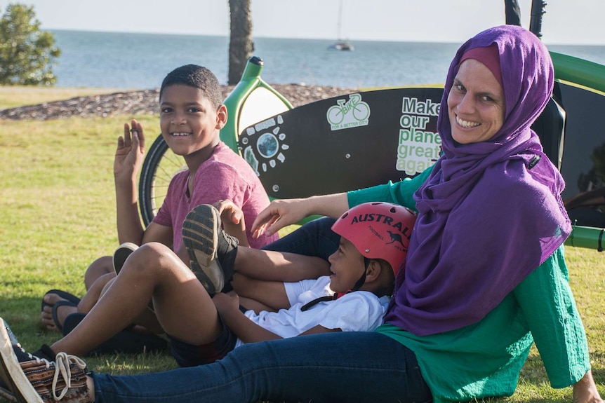 Mum with her two sons sitting on the ground.