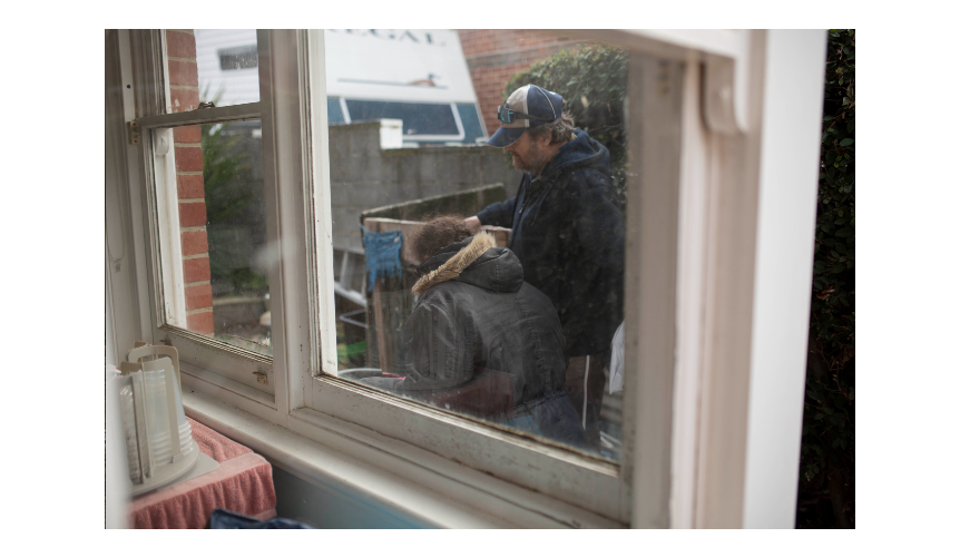 Two people at the front door of their home.