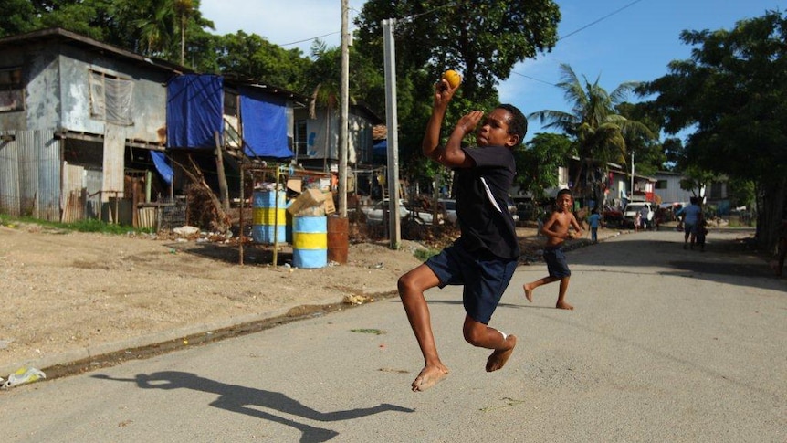A boy bowls during a game of street cricket in Papua New Guinea.
