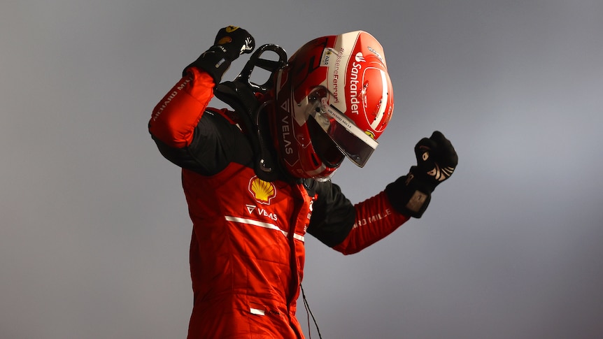 Race car driver pumps the air after winning a race. 