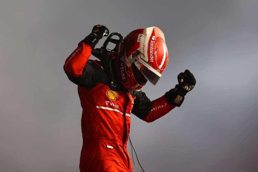 Race car driver pumps the air after winning a race. 