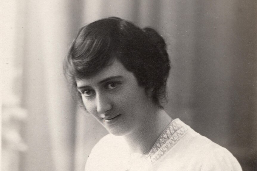 a young woman in an old, black and white photo in neat dress and her hair done.