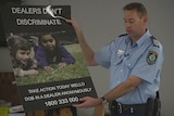 Senior Sergeant Simon Madgwick holds an anti-ice campaign poster.