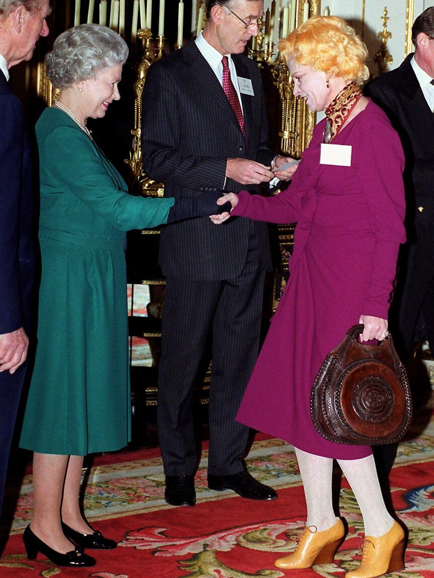 Queen Elizabeth II shakes the hand of fashion designer Vivienne Westwood