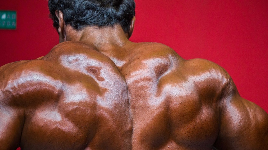 A bodybuilder flexes his back
