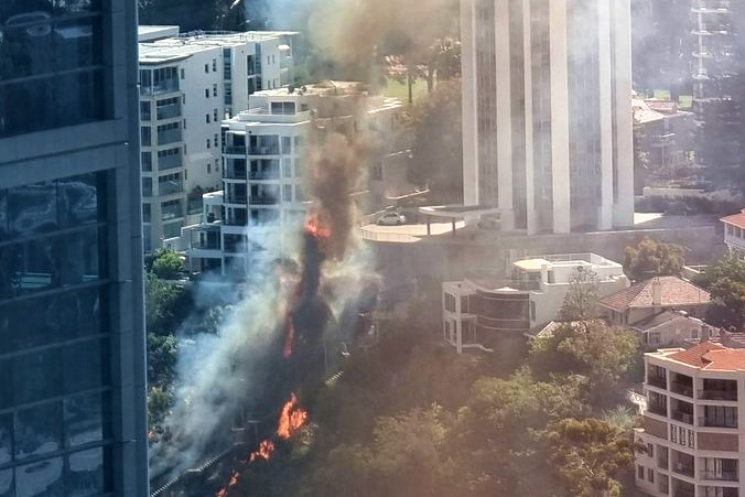 An outdoor staircase in a city area ablaze amid buildings