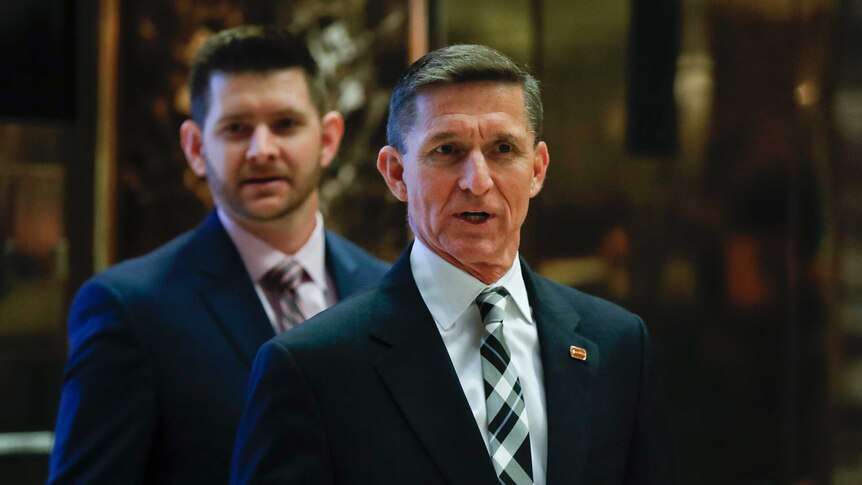 Michael Flynn stands up in front of media.