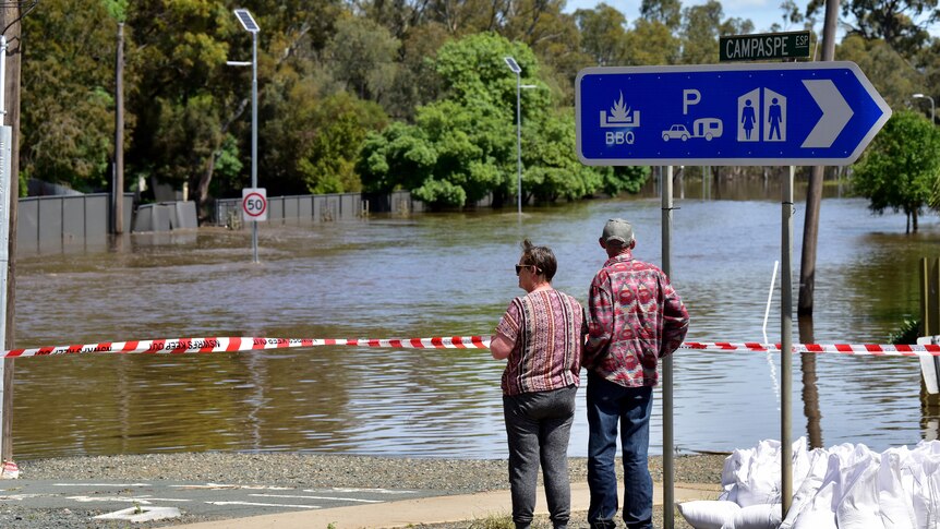 Two men look out at a flooded Campaspe Esplanade in the town of Echuca, Victoria