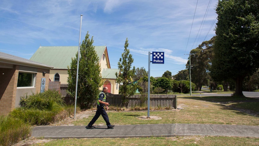 Policeman Paul Delaney strides from the police station in Toora.