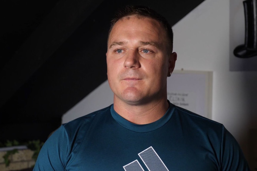 A man wearing a T-shirt standing in a room