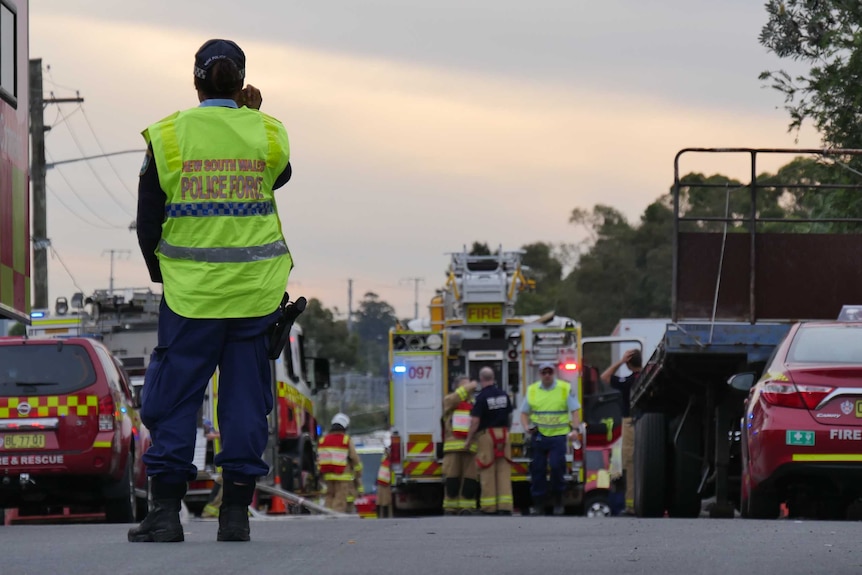 Fire crews on the road near a factory fire.