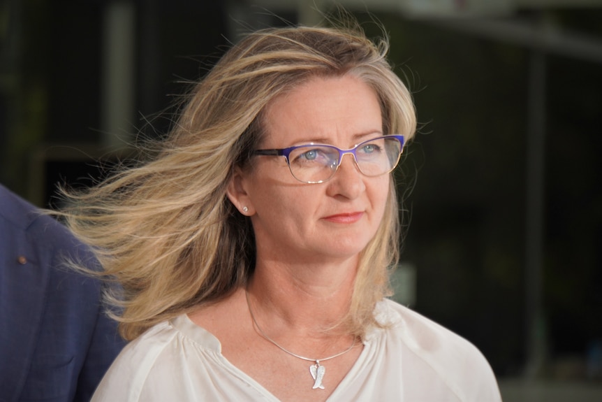 A woman with blond hair and glasses. 