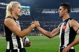 Darcy Moore and Scott Pendlebury shake hands on the MCG after a win
