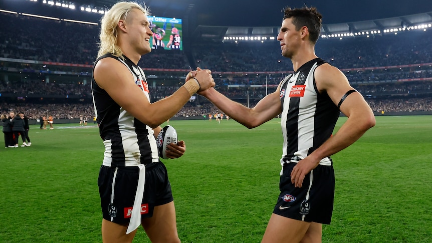 Darcy Moore and Scott Pendlebury shake hands on the MCG after a win