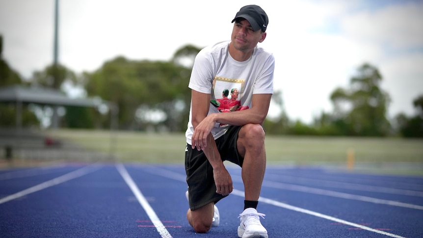 Matthew Centrowitz kneeling on a running track in a posed photo